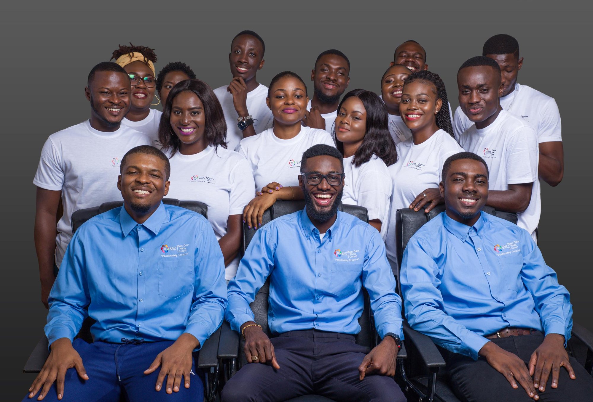 Smiling team in blue shirts and white tees